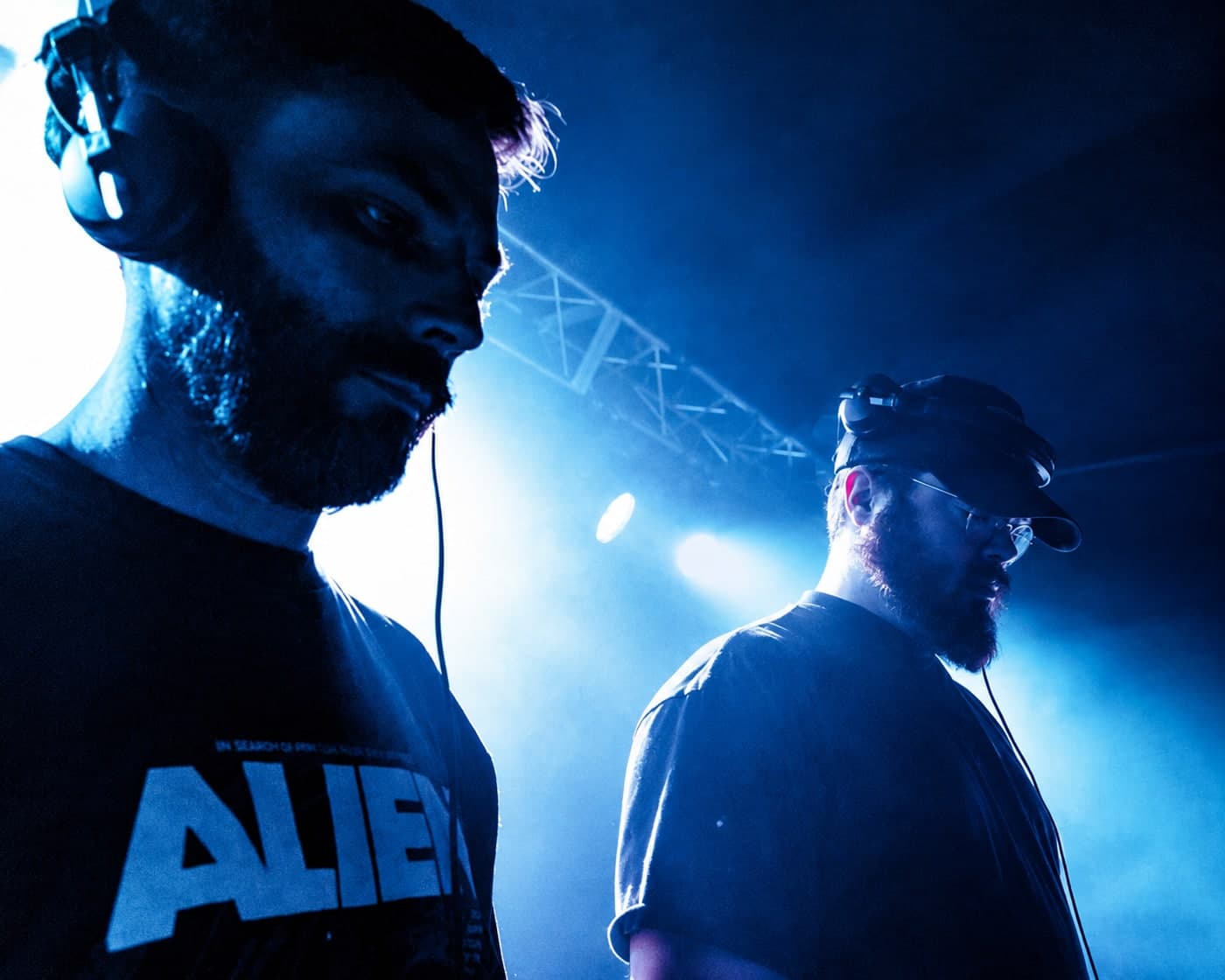 Two DJs backstage in blue stage lighting before a House Revival Project set