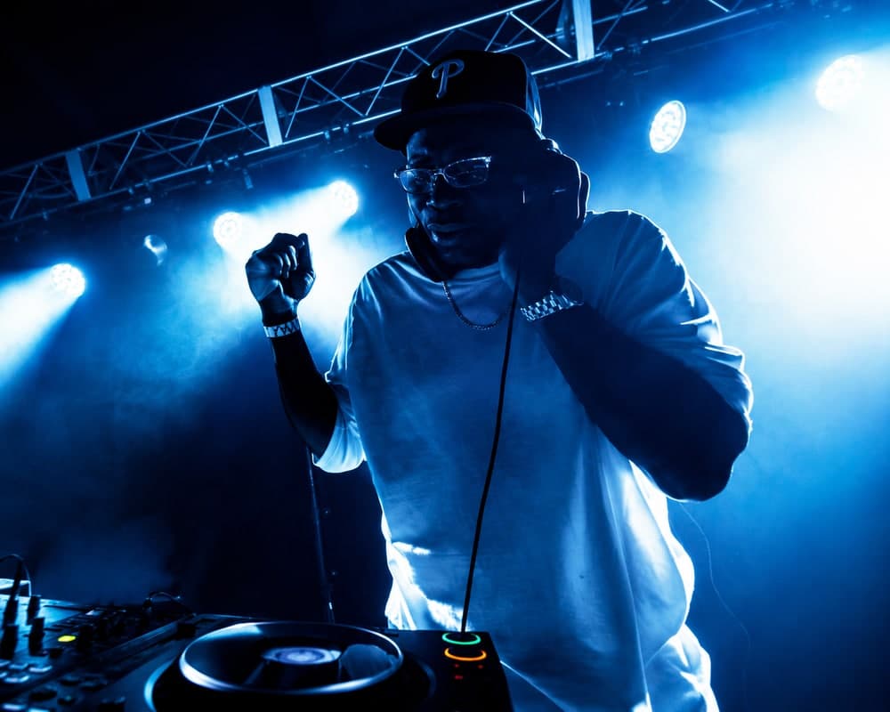 A DJ performing on CDJs under blue stage lighting